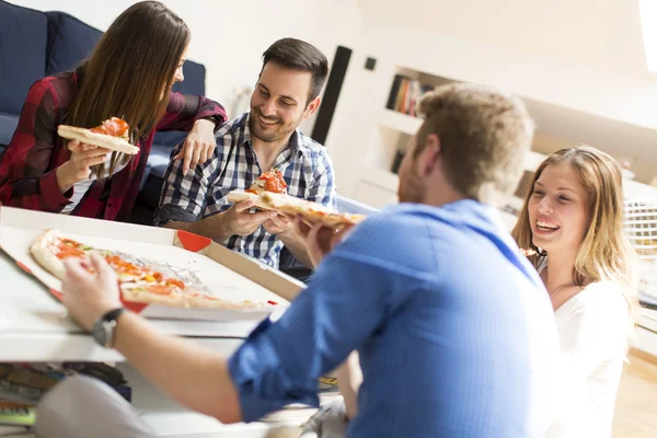 Vrienden eten van pizza in de kamer — Stockfoto