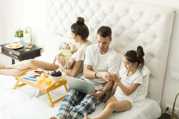 Junge Familie auf dem Bett — Stockfoto