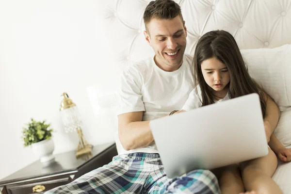 Ojciec i córka z laptopa w łóżku — Zdjęcie stockowe