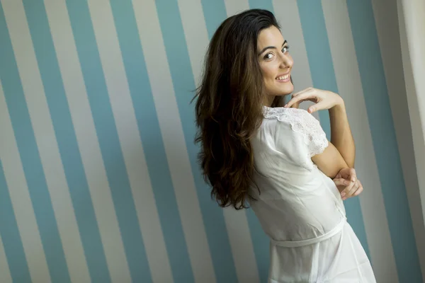 Young woman by the wall — Stock Photo, Image