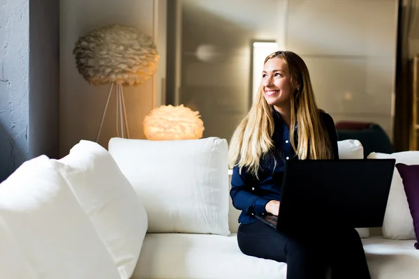 Young woman on a sofa — Stock Photo, Image