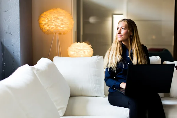 Jeune femme sur un canapé — Photo