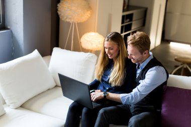 Dizüstü bilgisayar ile kanepede insanlar