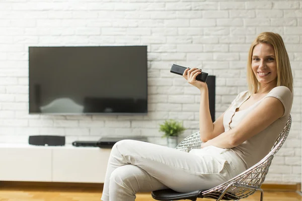 Femme avec une télécommande TV — Photo