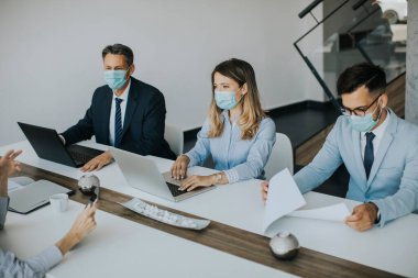 Bir grup iş adamı modern, aydınlık ofis içi bir toplantıda.