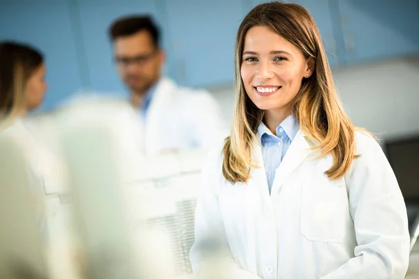 Young female scientist in white lab coat standing in the biomedical lab