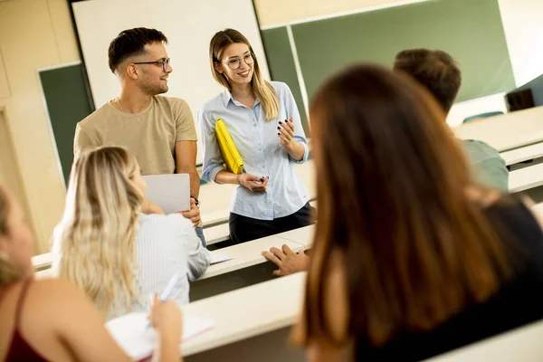 在课堂上与年轻的女助教组成的大学生小组 — 图库照片