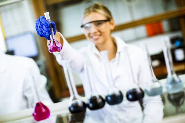 生化学研究室で液体を調べる若い女性科学者 — ストック写真