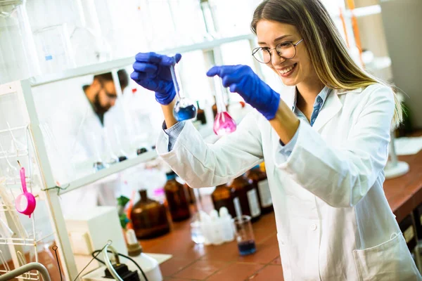生化学研究室で液体を調べる若い女性科学者 — ストック写真