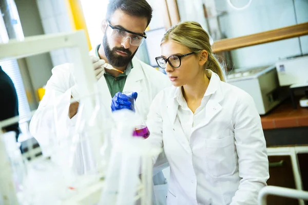 Jovens Pesquisadores Analisando Dados Químicos Laboratório — Fotografia de Stock