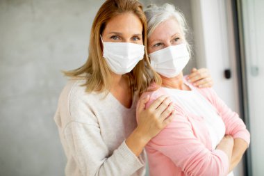 Coronavirus 'tan korunmak için evde tıbbi maskeler takan yaşlı bir kadın var.