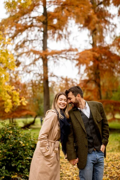 秋の公園を歩くハンサムな若いカップル — ストック写真