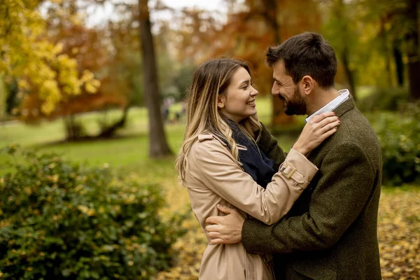Güz parkında yürüyen yakışıklı genç çift.