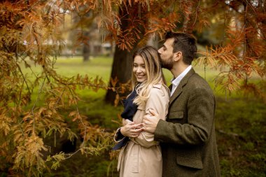 Güz parkında yakışıklı genç bir çift.