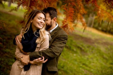 Güz parkında yakışıklı genç bir çift.
