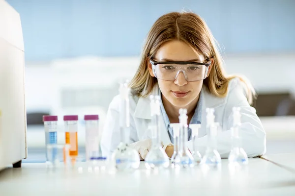 Jovem Pesquisadora Médica Científica Olhando Para Frascos Com Soluções Laboratório — Fotografia de Stock