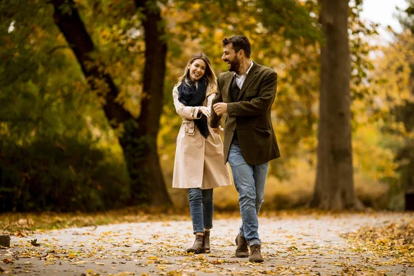 一对年轻貌美的夫妇在秋天的公园里散步 — 图库照片