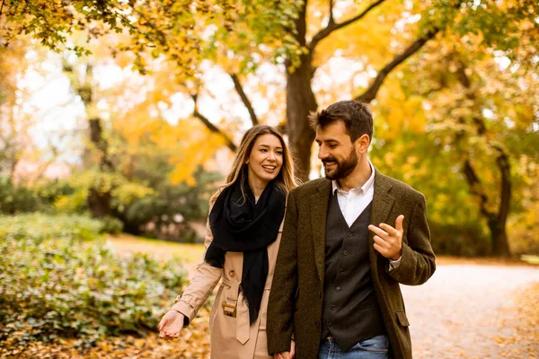 一对年轻貌美的夫妇在秋天的公园里散步 — 图库照片