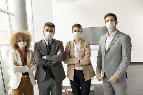 Group of young business people standing in the office and wear masks as protection from corona virus