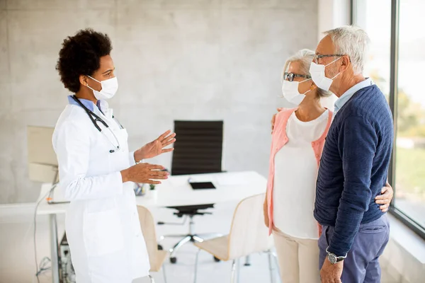 Senior Coule Met Beschermende Gezichtsmaskers Krijgen Nieuws Van Zwarte Vrouwelijke — Stockfoto