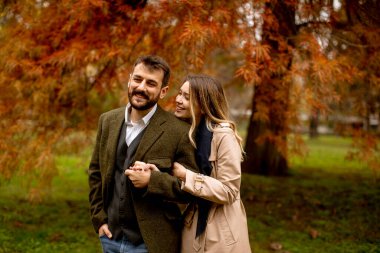 Güz parkında yakışıklı genç bir çift.