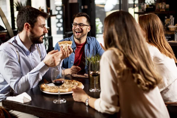 Group of young people having dinner in the restaurant