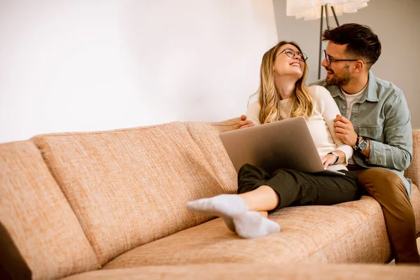 Stiliga Unga Par Använder Laptop Tillsammans Medan Sitter Soffan Hemma — Stockfoto