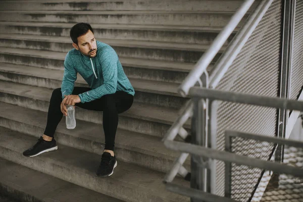 Junger Mann Rastet Beim Training Mit Wasserflasche Städtischem Umfeld Aus — Stockfoto