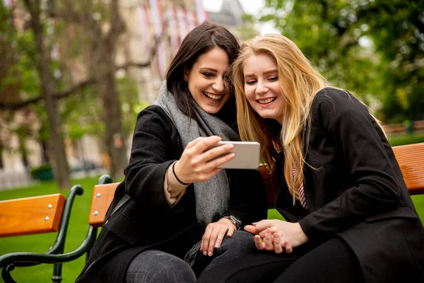 若い女性の観光客は オーストリアのウィーンの中心部にあるベンチでモバイル写真を撮ります — ストック写真