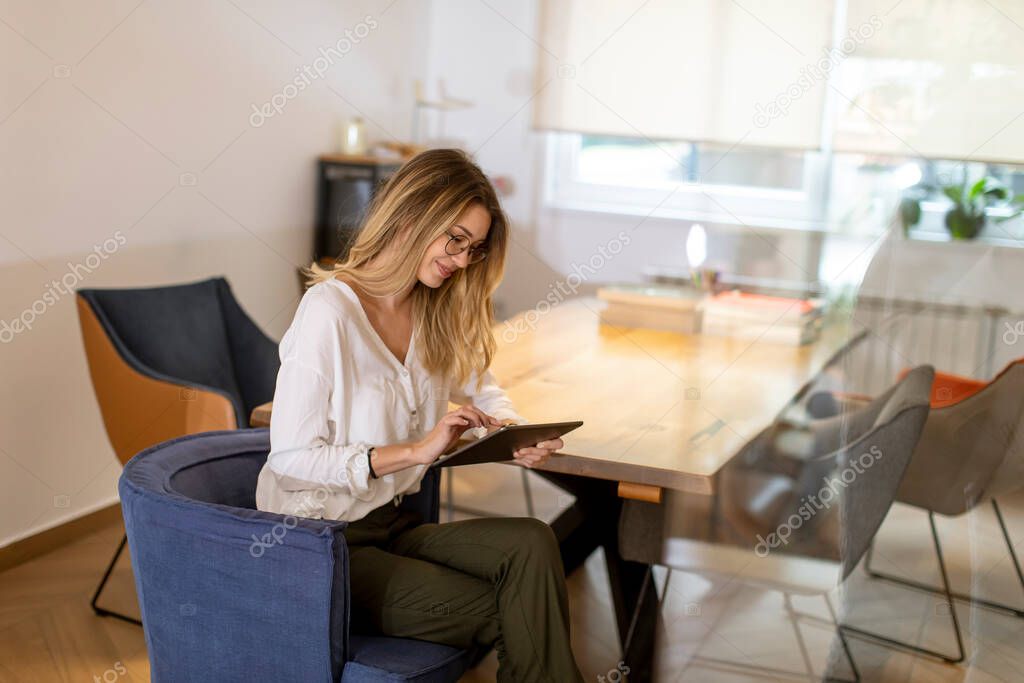 Pretty young woman working with digital tablet in the office