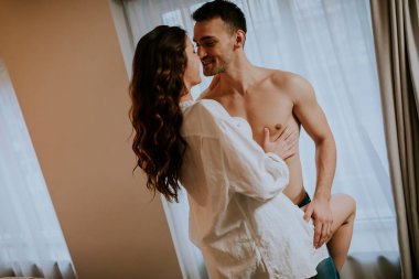 Sevecen genç bir çift. Dairenin penceresinin önünde duruyorlar.