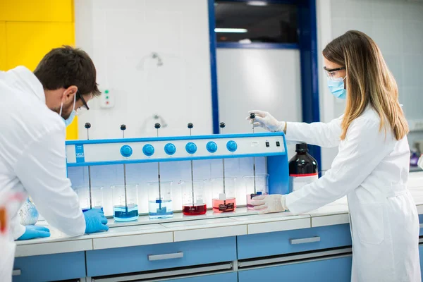 Jovens Pesquisadores Analisando Dados Químicos Floculador Laboratório — Fotografia de Stock