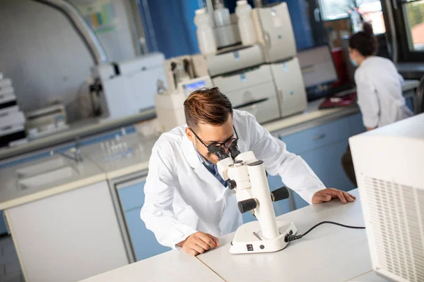 Guapo Joven Científico Con Bata Blanca Trabajando Con Microscopio Binocular —  Fotos de Stock