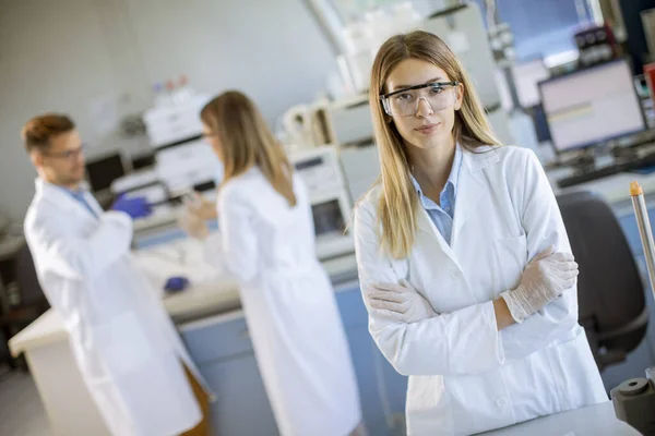 Beyaz Laboratuvar Önlüklü Genç Kadın Bilim Adamı Biyomedikal Laboratuarda Duruyor — Stok fotoğraf