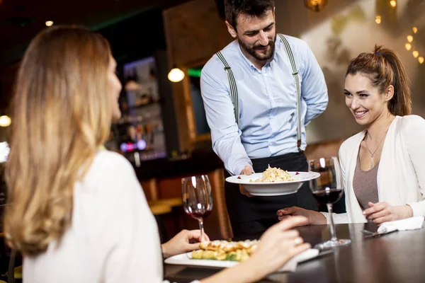 Stilig Ung Servitör Som Serverar Mat Till Kvinnliga Kunder Restaurangen — Stockfoto