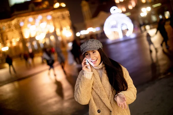 Noel Zamanı Sokakta Cep Telefonunu Kullanan Güzel Genç Bir Kadın — Stok fotoğraf