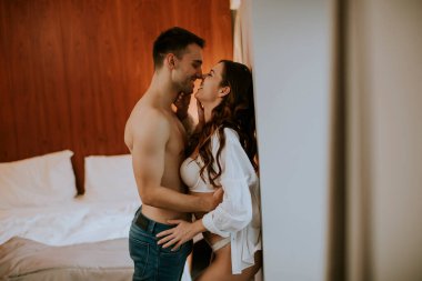 Genç çift dairenin odasında birbirlerine sarılıyorlar.