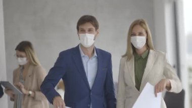 Bir grup heyecanlı iş adamı kutlama yapıyor ve kağıtları havaya fırlatıyor.