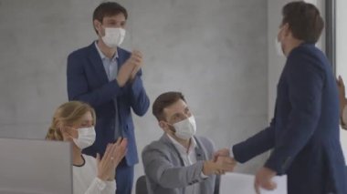 İş adamlarının bir toplantısı var ve ofiste çalışıyorlar. Koronavirüsten korunmak için maske takıyorlar.
