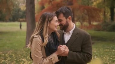 Güz parkında yürüyen yakışıklı genç çift.