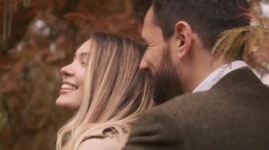 Güz parkında yürüyen yakışıklı genç çift.