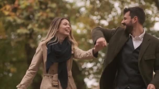 秋の公園を歩くハンサムな若いカップル — ストック動画
