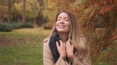 Güz parkında duran güzel genç kadın