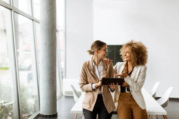 Dos Mujeres Jóvenes Sosteniendo Tableta Digital Trabajando Oficina Moderna — Foto de Stock