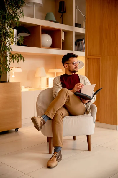 Jovem Bonito Roupas Casuais Com Óculos Lendo Livro Casa — Fotografia de Stock