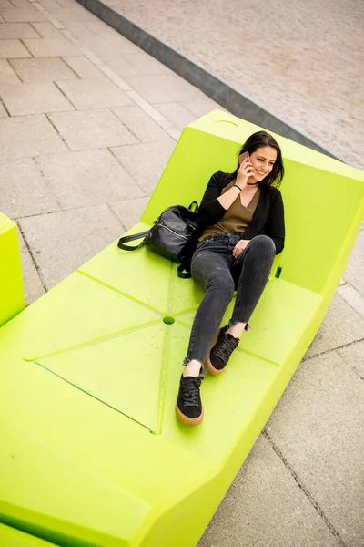 Ung Kvinna Sitter Staden Och Använder Mobiltelefon Stadskoncept — Stockfoto