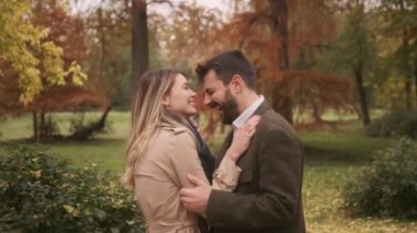 Güz parkında yürüyen yakışıklı genç çift.