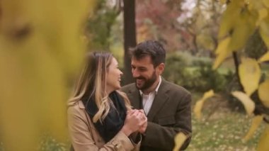 Güz parkında yürüyen yakışıklı genç çift.