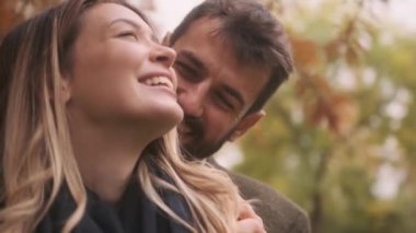 Güz parkında yürüyen yakışıklı genç çift.