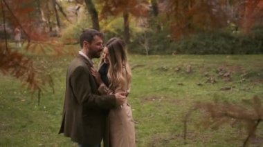 Güz parkında yürüyen yakışıklı genç çift.